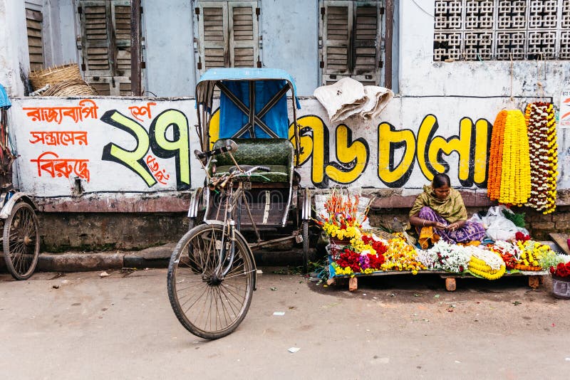 Florece al comerciante con el triciclo en el mercado de la mañana en Kolkata, la India imagen de archivo Florece al comerciante con el triciclo en el mercado de la mañana en Kolkata, la India imagen de archivo