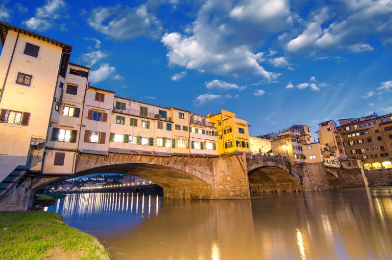 Florence, Italy. Wonderful sunset above Magnificent Ponte Vecchio - Old Bridge view from Arno river bank