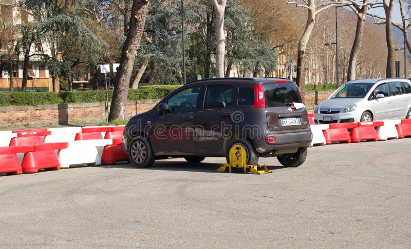 Florenceâ€Ž, Italy, Car wheel blocked by wheel lock tool on illegal parking violation