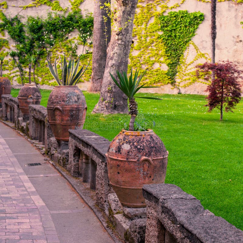 Florero de la arcilla con las flores en el cuadrado acogedor de la ciudad europea fotos de archivo libres de regalías Florero de la arcilla con las flores en el cuadrado acogedor de la ciudad europea fotos de archivo libres de regalías