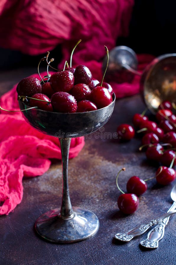 Florero viejo con las cerezas en la tabla fotos de archivo Florero viejo con las cerezas en la tabla fotos de archivo
