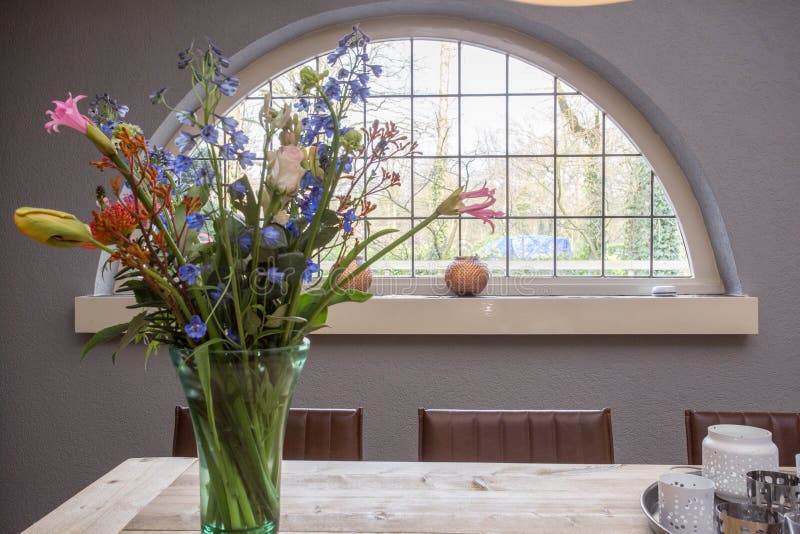 Cozy little vintage window with colorful flower bush on the table in house. Cozy little vintage window with colorful flower bush on the table in house