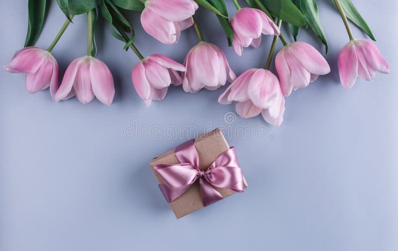 Flores e presente cor-de-rosa das tulipas sobre claro - fundo azul Cartão ou convite do casamento imagens de stock royalty free Flores e presente cor-de-rosa das tulipas sobre claro - fundo azul Cartão ou convite do casamento imagens de stock royalty free