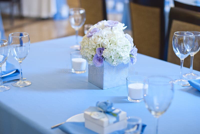 Flores e velas bonitas na tabela no dia do casamento Toalha de mesa azul da decoração da cor imagem de stock Flores e velas bonitas na tabela no dia do casamento Toalha de mesa azul da decoração da cor imagem de stock