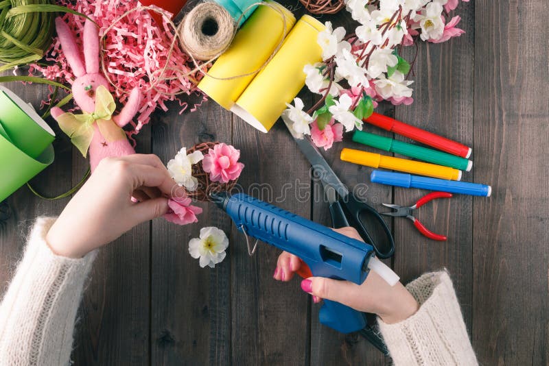 Flores hechas a mano del pegamento de la mujer con el arma del derretimiento imagenes de archivo Flores hechas a mano del pegamento de la mujer con el arma del derretimiento imagenes de archivo