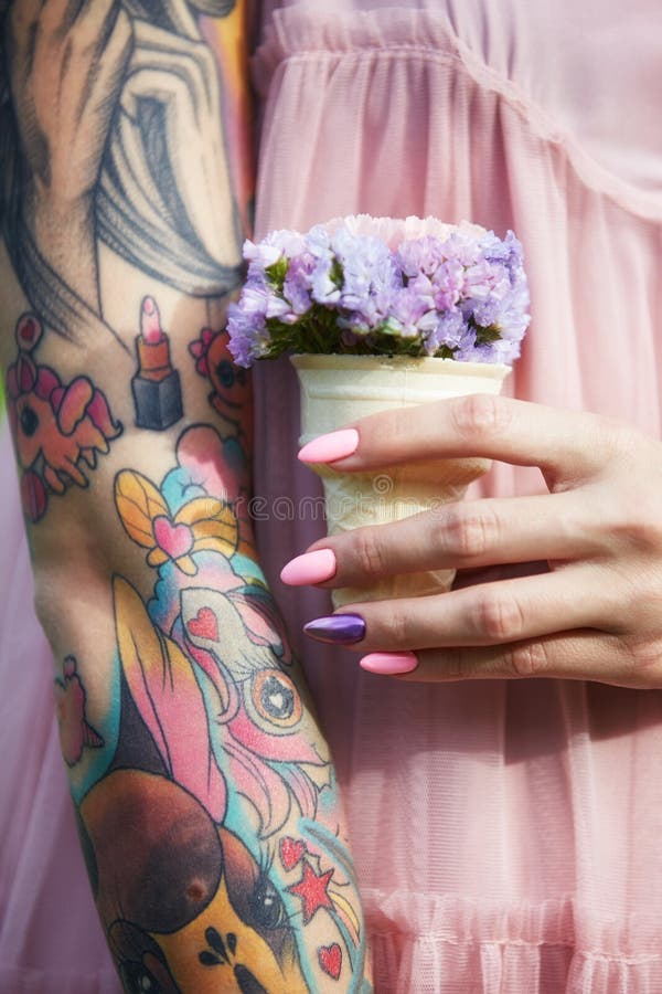 Flores hermosas en las manos de una muchacha con los tatuajes, cosméticos Flores del verano y maquillaje brillante en los clavos fotografía de archivo libre de regalías Flores hermosas en las manos de una muchacha con los tatuajes, cosméticos Flores del verano y maquillaje brillante en los clavos fotografía de archivo libre de regalías