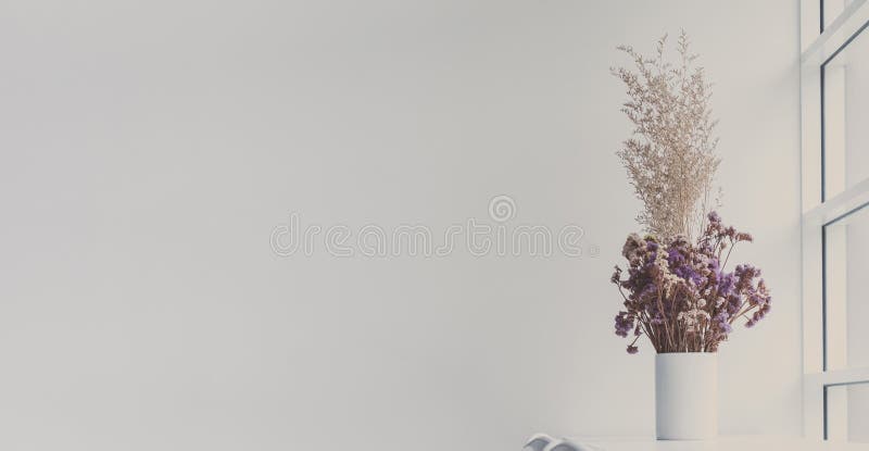 Dry flowers in white jar on table close to window with copy space. Minimal and simple stylish fo decoration for living room or modern residential or apartment. Free area for message, quote or text. Dry flowers in white jar on table close to window with copy space. Minimal and simple stylish fo decoration for living room or modern residential or apartment. Free area for message, quote or text