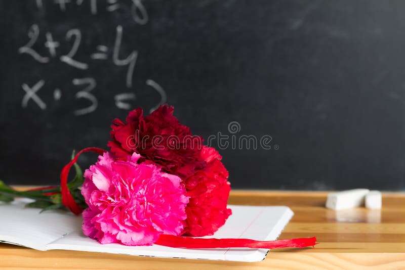 Flores y pizarra en concepto del fondo del día del profesor de la sala de clase imagenes de archivo Flores y pizarra en concepto del fondo del día del profesor de la sala de clase imagenes de archivo