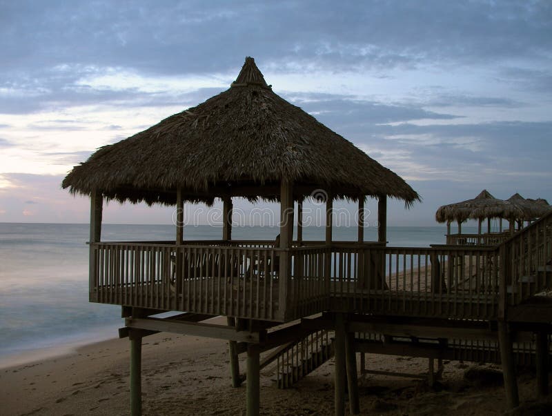 Amanecer está viniendo sobre el revelar línea de cabanas sobre el alguno Playa casas.