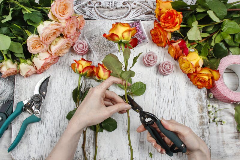 Florist bei der Arbeit Frau, die Hochzeitsblumenstrauß von den orange Rosen macht stockfoto Florist bei der Arbeit Frau, die Hochzeitsblumenstrauß von den orange Rosen macht stockfoto