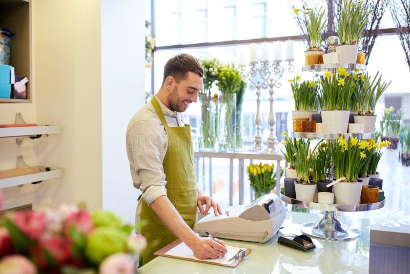 Florist man with clipboard at flower shop counter