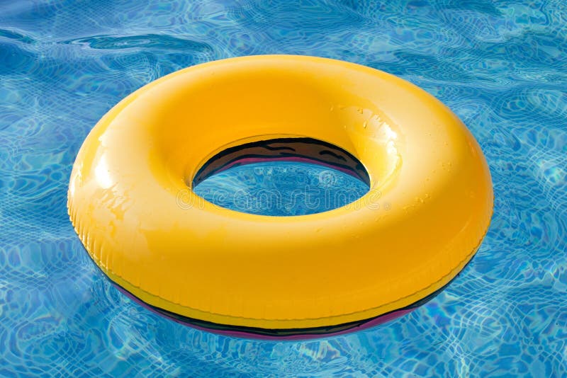 Flotador amarillo que flota en la piscina imágenes de archivo libres de regalías Flotador amarillo que flota en la piscina imágenes de archivo libres de regalías