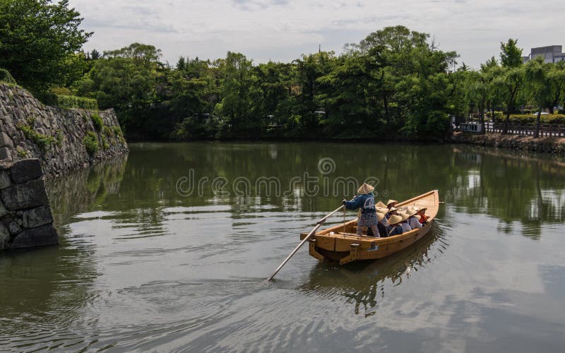 Flotador tradicional con un grupo de turistas y de guía en la fosa interna del castillo de Himeji Himeji, Hyogo, Jap?n, Asia fotografía de archivo Flotador tradicional con un grupo de turistas y de guía en la fosa interna del castillo de Himeji Himeji, Hyogo, Jap?n, Asia fotografía de archivo