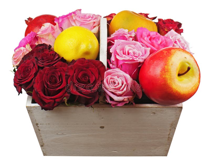 Flower arrangement of red roses and fruits in wooden basket isolated on white background.
