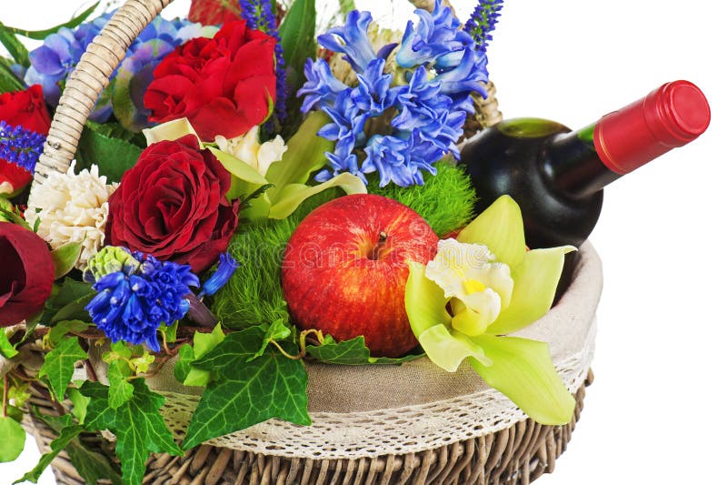 Flower arrangement of roses, orchids, fruits and bottle of wine