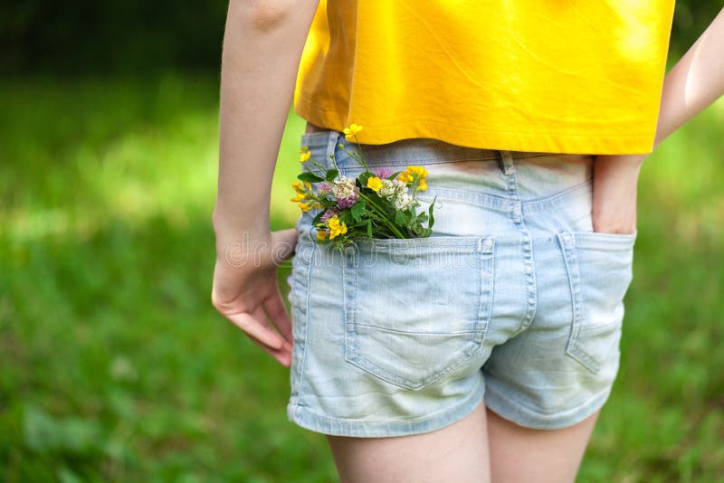 Flower in a large pocket of jeans trousers, summer concept