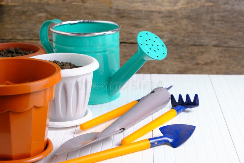 Flower Pots, Watering Can and Garden Tools on White Countertop Stock