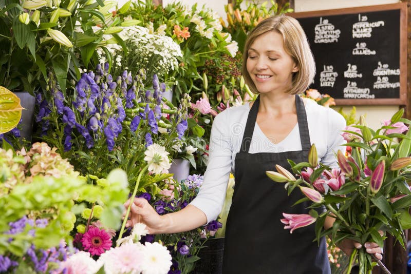 Flower shop smiling woman working στοκ φωτογραφία με δικαίωμα ελεύθερης χρήσης