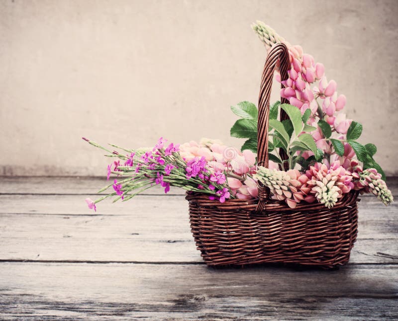 Flowers in basket on old background