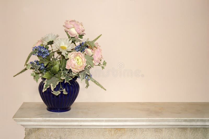 Blue vase full of colorful flowers on a commode. Blue vase full of colorful flowers on a commode
