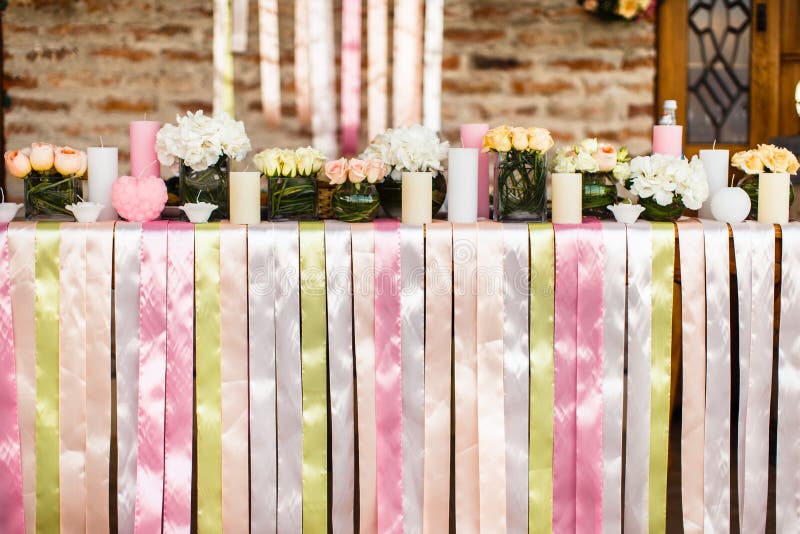 The Flowers, Candles and Colored Ribbons on the Wedding Table Stock