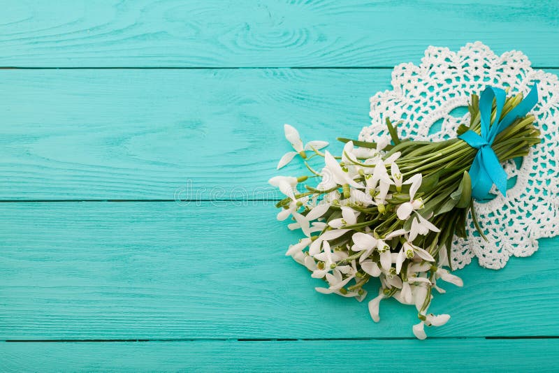 Flowers and lace ribbon on blue wooden background