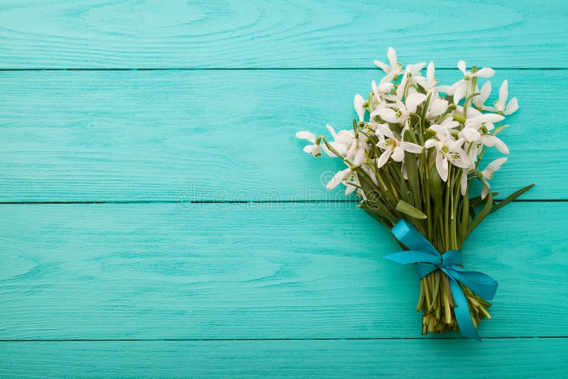 Flowers and lace ribbon on blue wooden background