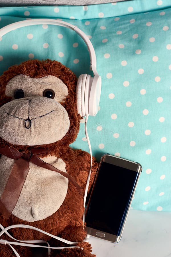 Fluffy Monkey Toy with Headphones and a Smartphone on a Green Blanket Stock Photo Image of