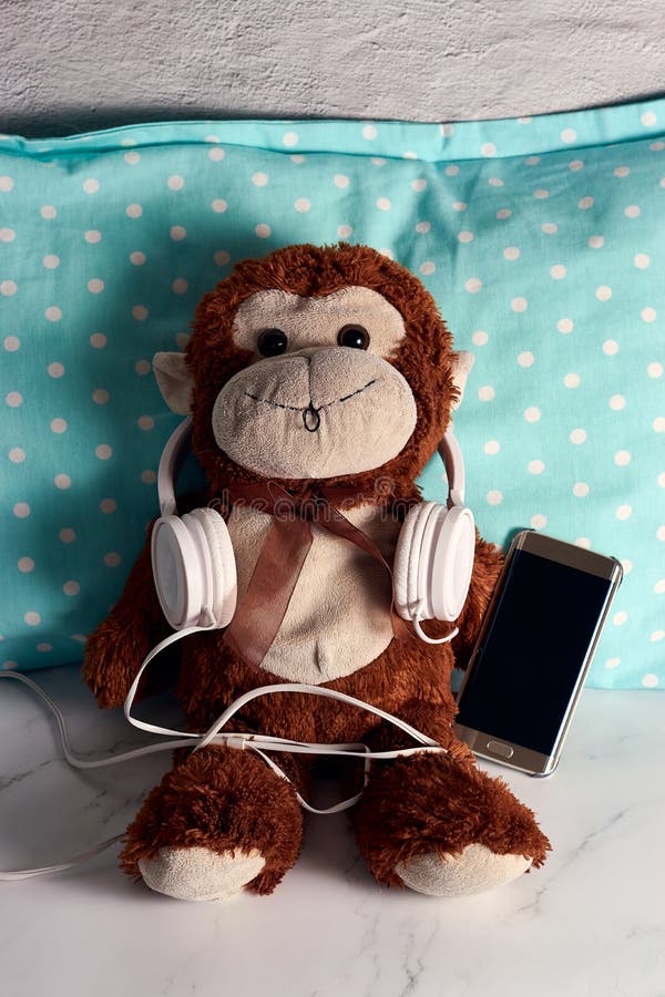 Fluffy Monkey Toy with Headphones and a Smartphone on a Green Blanket Stock Image Image of