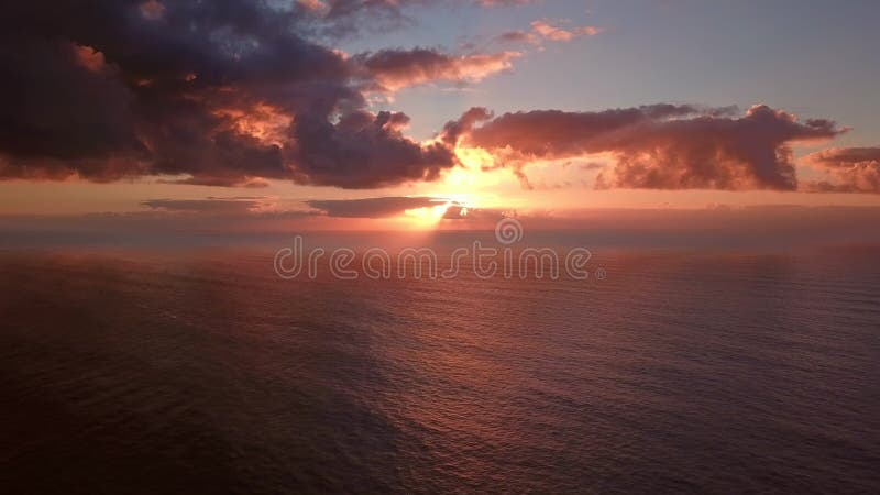 Flug bis Sonnenuntergang in dramatischen Wolken über Meer