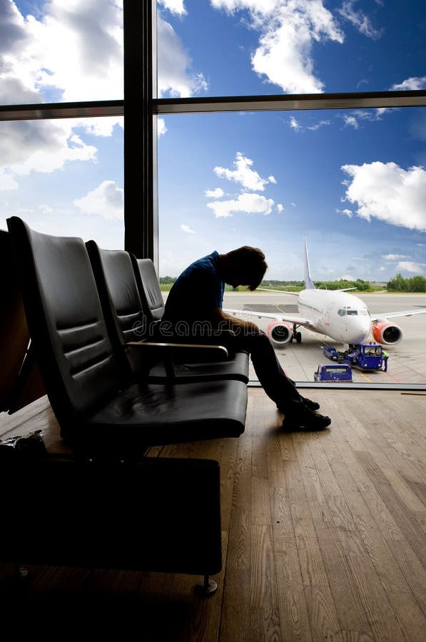 A male waiting sleeping in the airport. A male waiting sleeping in the airport