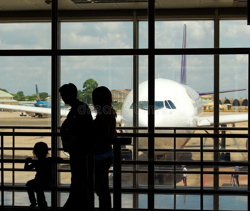 A family at an airport terminal with aeroplane in the background. A family at an airport terminal with aeroplane in the background