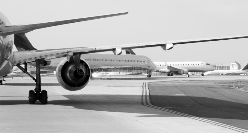 Black and white image of airliners taxiing across an airport. Black and white image of airliners taxiing across an airport