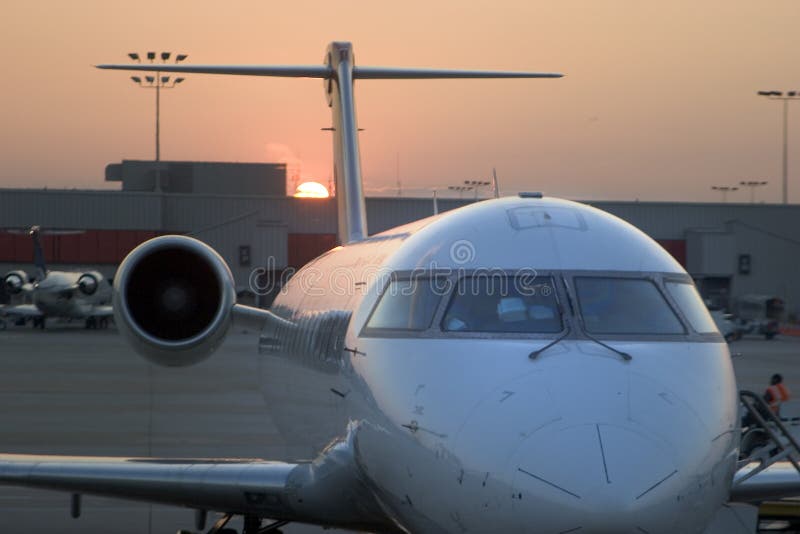 View of an airplane at the gate during sunset. View of an airplane at the gate during sunset