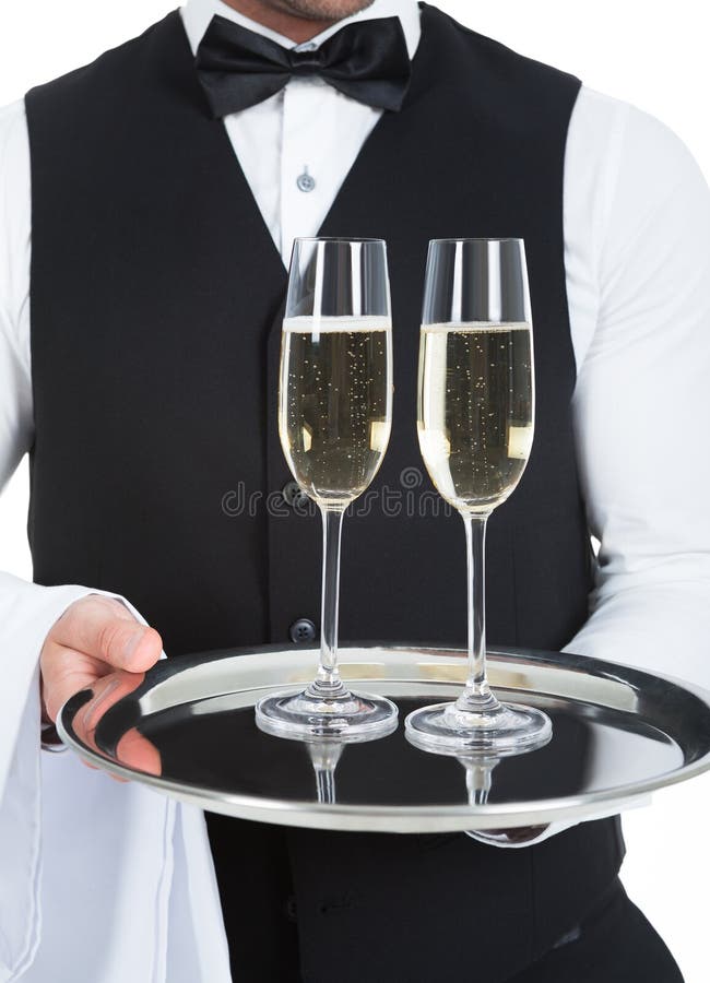 Midsection of waiter carrying champagne flutes on tray over white background. Midsection of waiter carrying champagne flutes on tray over white background