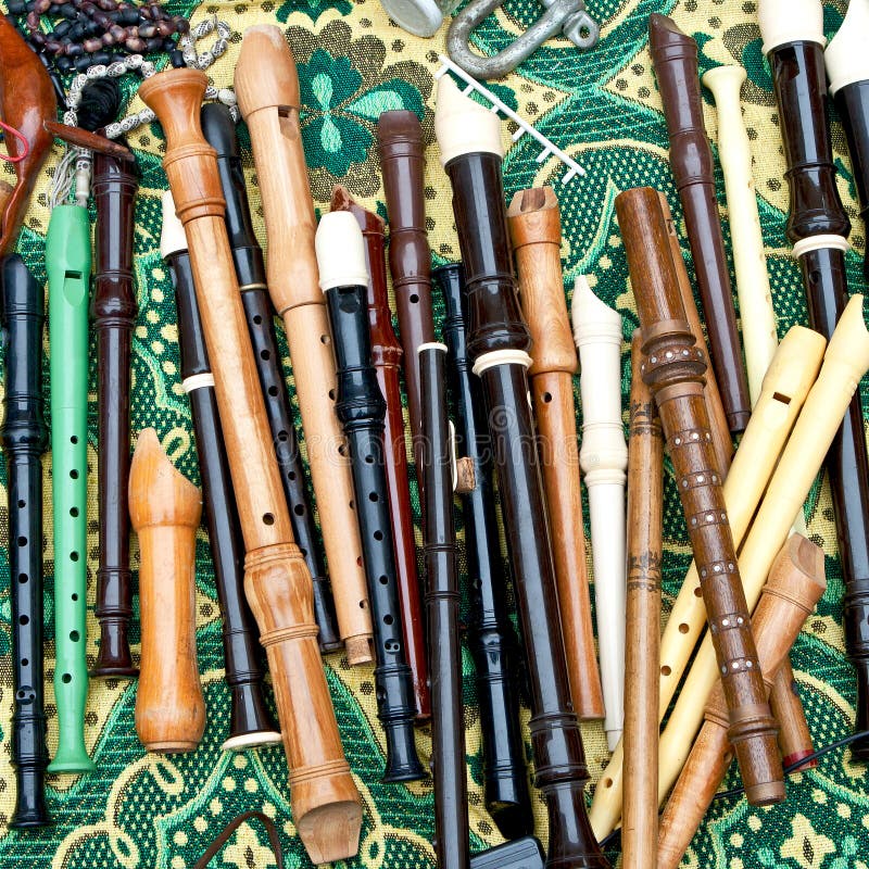 Group of flutes of different types, colors and sizes on a  bright colorful tablecloth at the flea market in Tel Aviv. Useful for background. Group of flutes of different types, colors and sizes on a  bright colorful tablecloth at the flea market in Tel Aviv. Useful for background