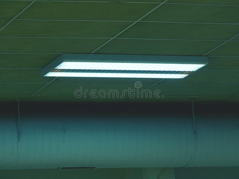 Fluorescent Light Fixture on a White Ceiling in Warehouse Stock Photo