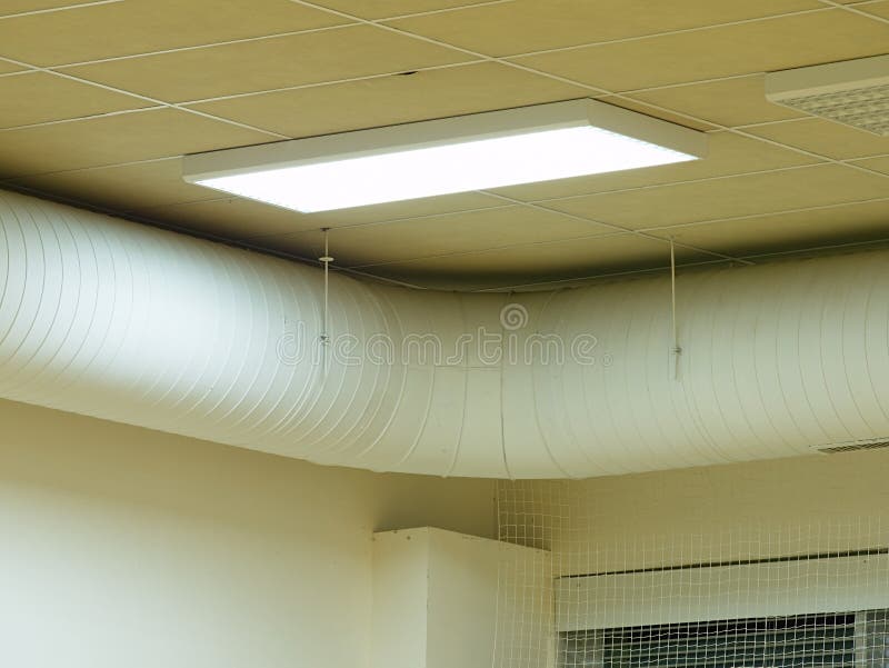 Fluorescent Light Fixture on a White Ceiling in Warehouse Stock Image