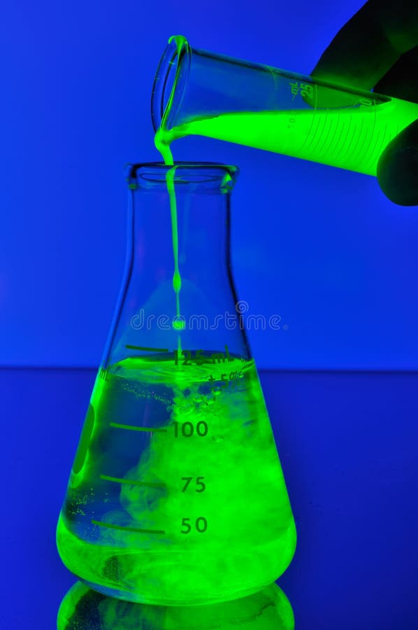 Fluorescent liquid falling in flask royalty free stock photography Fluorescent liquid falling in flask royalty free stock photography