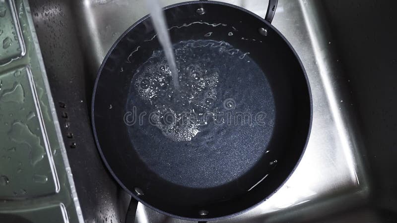 Flusso d'acqua nel lavandino. il flusso d'acqua rientra nella chiusura di messa a fuoco selettiva del pannello