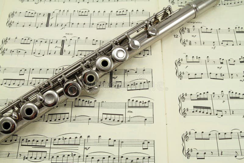 A silver flute resting on a music book. Paper notation stock images, royalty-free photos and pictures