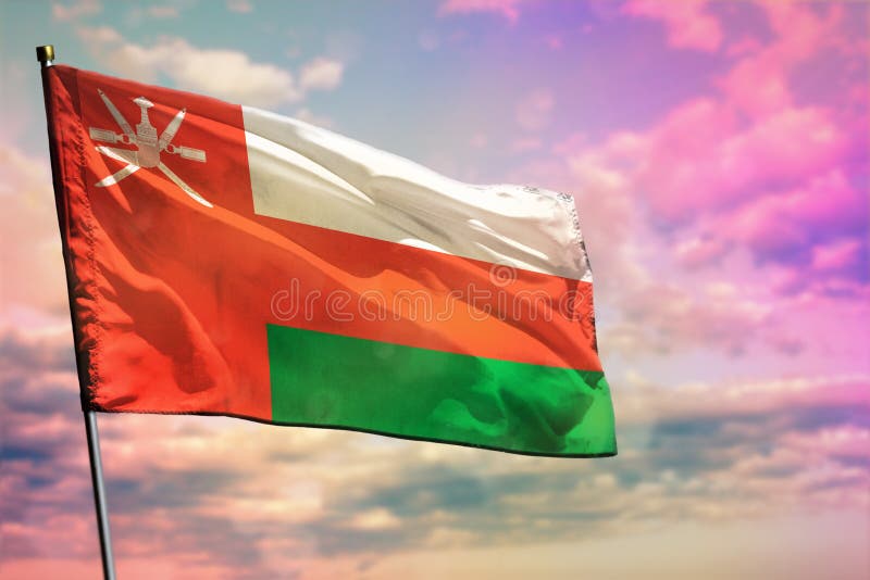 Fluttering Oman flag on colorful cloudy sky background. Prosperity concept royalty free stock photos