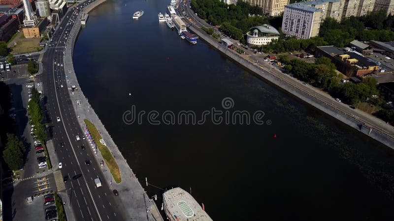 Fluxos largos espetaculares do rio no coração de construções altas próximas do centro urbano