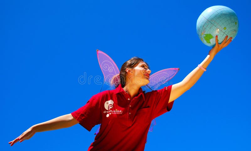 Caucasian white young woman with butterfly wings wearing the Cranberry Dreamstime Polo Shirt, holding a globe in her hand and dreaming about flying away up to the blue sky to discover the world of stock photography. Caucasian white young woman with butterfly wings wearing the Cranberry Dreamstime Polo Shirt, holding a globe in her hand and dreaming about flying away up to the blue sky to discover the world of stock photography