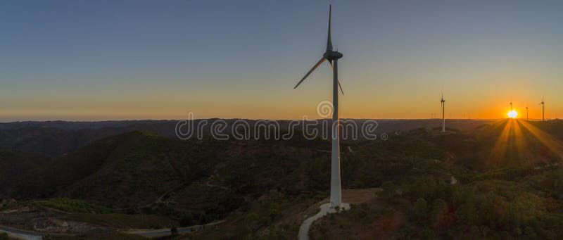 Flyg- kontur för turbiner för vindlantgård på solnedgången Ren förnybara energikällormakt som frambringar väderkvarnar arkivfoto Flyg- kontur för turbiner för vindlantgård på solnedgången Ren förnybara energikällormakt som frambringar väderkvarnar arkivfoto