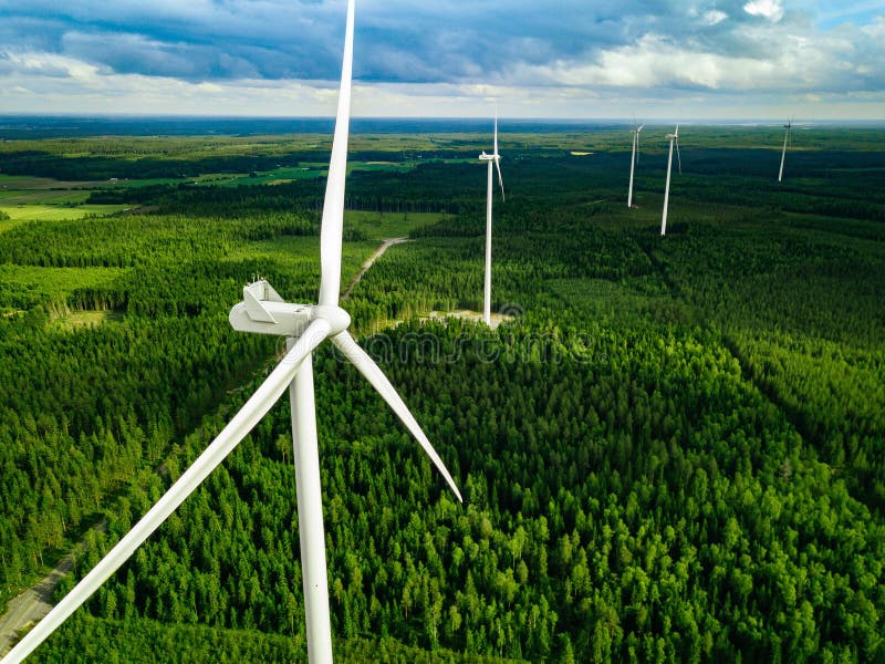 Flyg- sikt av väderkvarnar i sommarskog i Finland Vindturbiner för elkraft med rent och förnybara energikällor royaltyfria foton