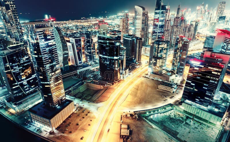 Flyg- sikt över en stor futuristisk stad vid natt Affärsfjärd, Dubai, Förenade Arabemiraten