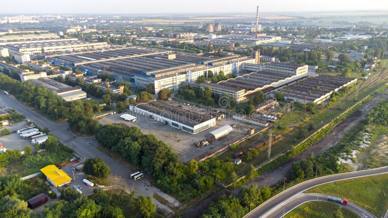 Aerial drone view flight over industrial zone on summer morning. Top view of large logistics park with factories, plants, thermoelectric power station, garages, hangars in city. Aerial drone view flight over industrial zone on summer morning. Top view of large logistics park with factories, plants, thermoelectric power station, garages, hangars in city.