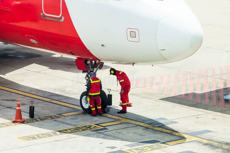 Airplane in airport serviced by the ground crew before departure at Don Mueang international Airport THailand. Airplane in airport serviced by the ground crew before departure at Don Mueang international Airport THailand