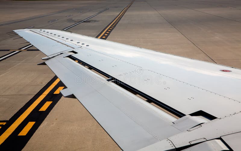 Flygplanflygplanvänsterkanten på flygplatsjordtecken royaltyfri bild Flygplanflygplanvänsterkanten på flygplatsjordtecken royaltyfri bild
